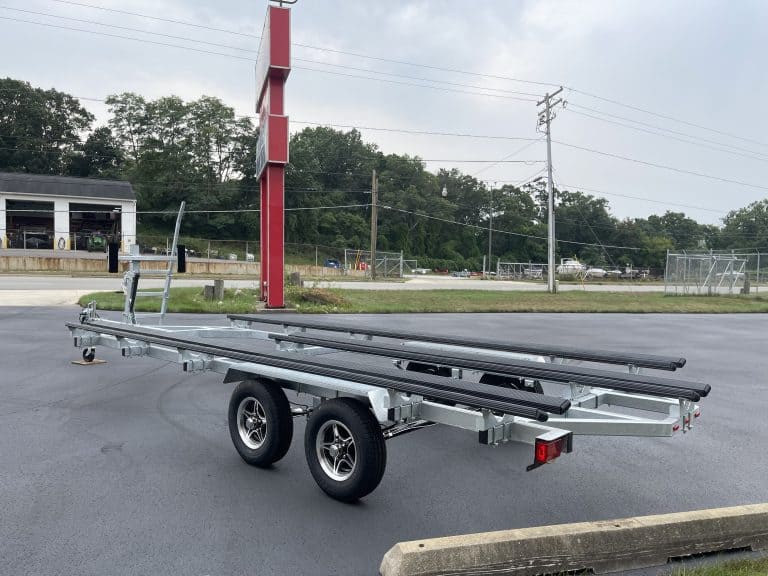 Boat trailer with black and silver frame parked outdoors near Hall's Sport Center.