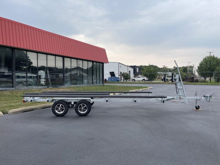 Empty boat trailer parked outside Hall's Sport Center in a parking lot.