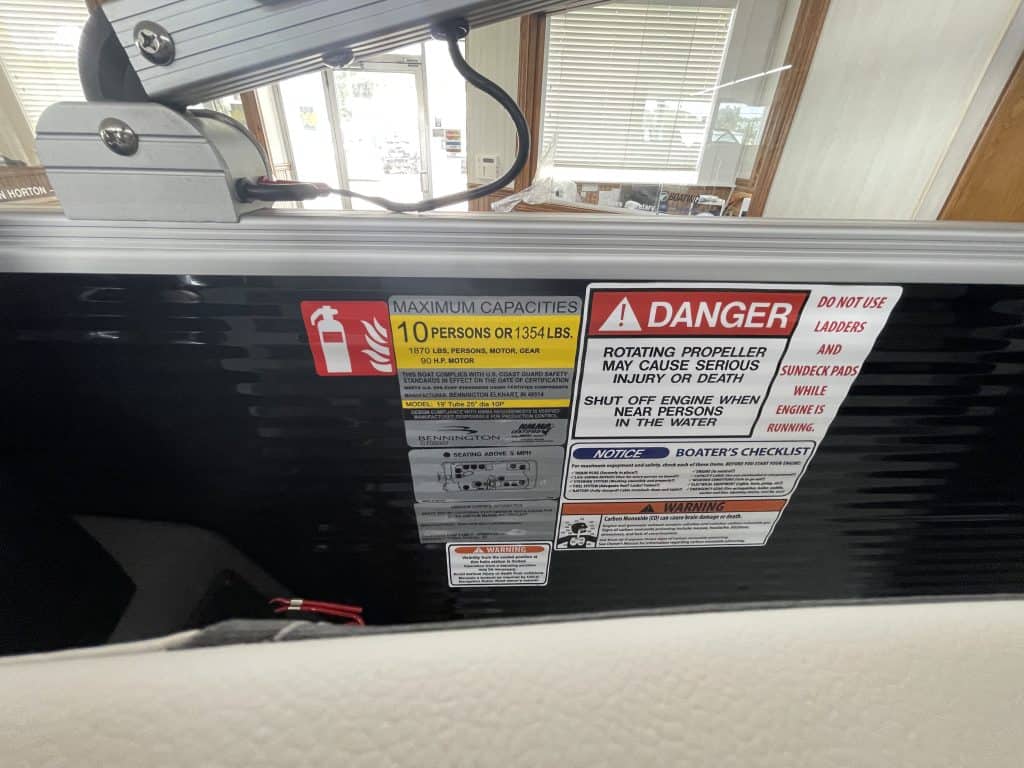 Boat safety labels showing maximum capacity and warnings.