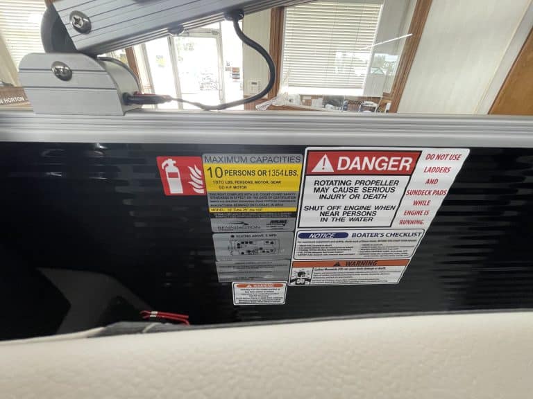 Boat safety labels showing maximum capacity and warnings.