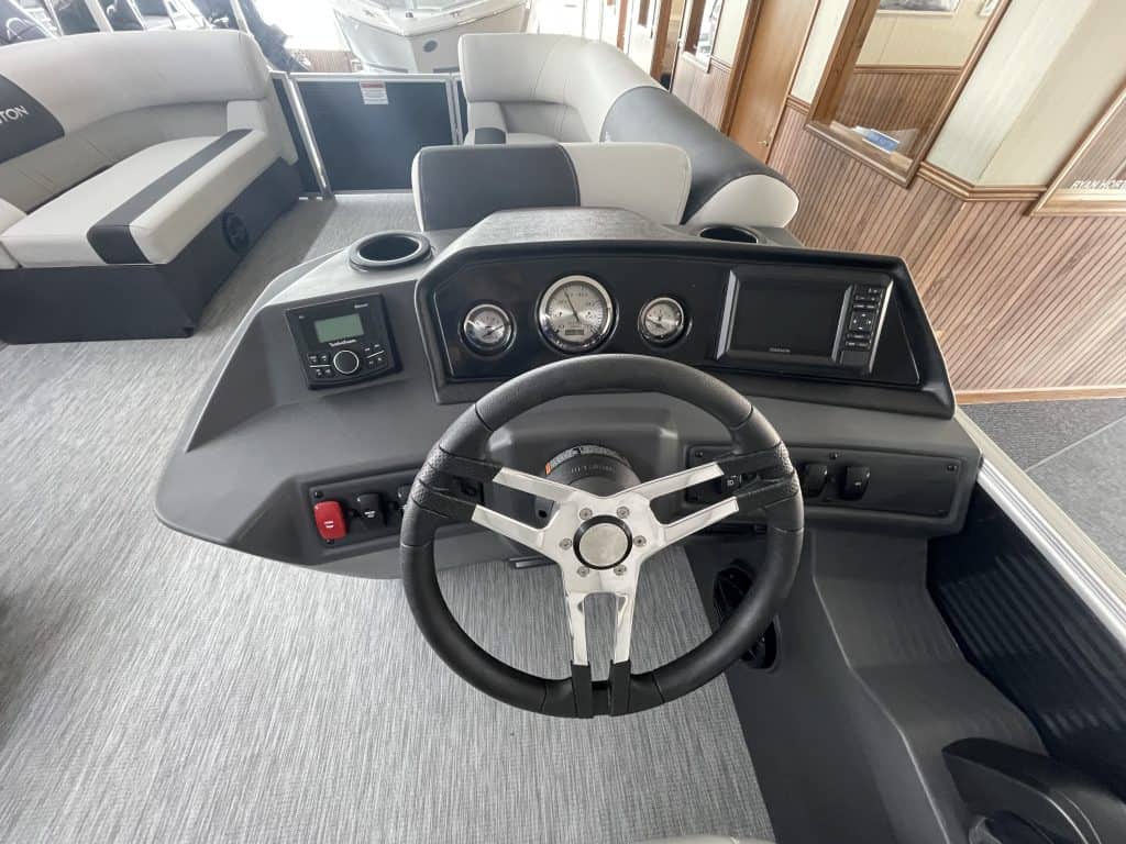 Boat dashboard with steering wheel and gauges at Hall's Sport Center.