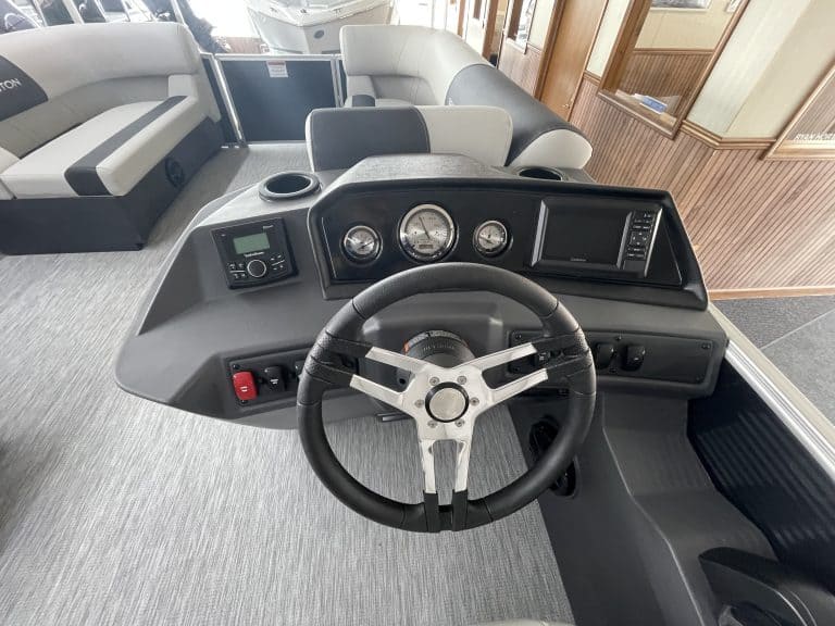 Boat dashboard with steering wheel and gauges at Hall's Sport Center.