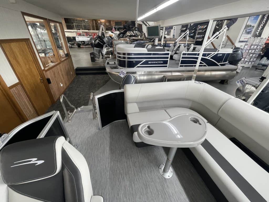 Indoor boat showroom with pontoon boats and seating area at Hall's Sport Center.
