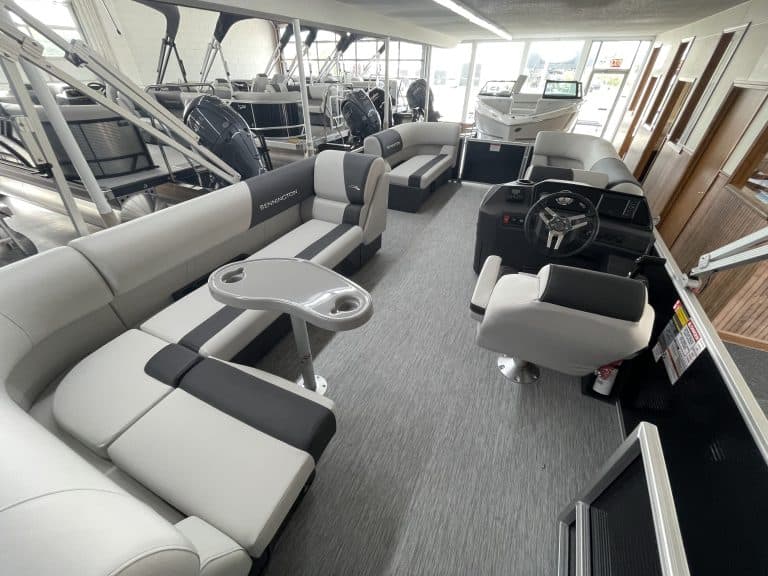 Indoor boat showroom with various boats and seating areas at Hall's Sport Center.
