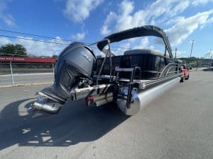 Bennington 22S1 SSR pontoon boat with outboard motor on a parking lot.
