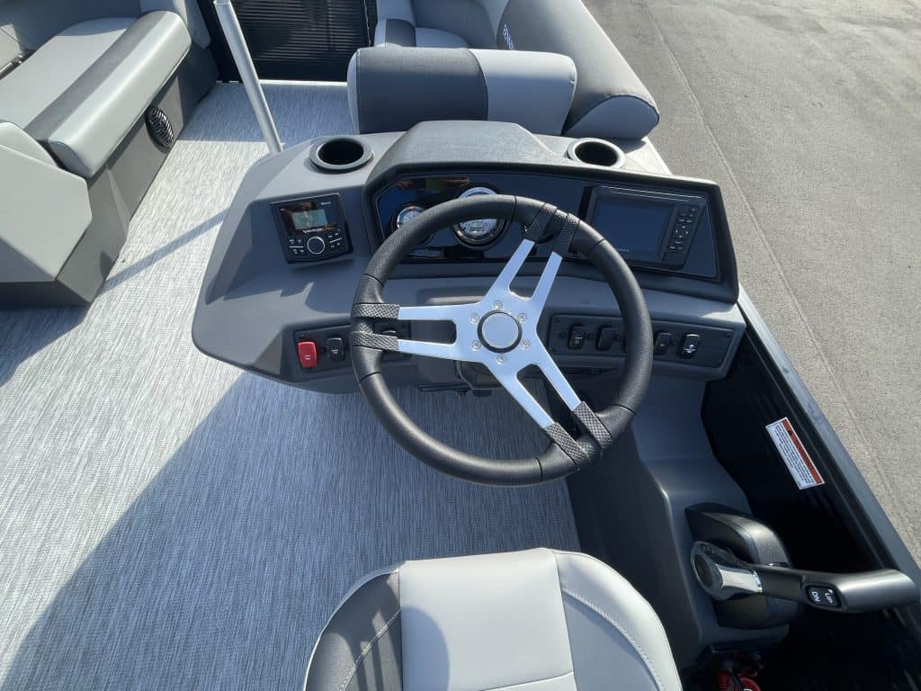 Boat dashboard with steering wheel and controls at Hall's Sport Center.
