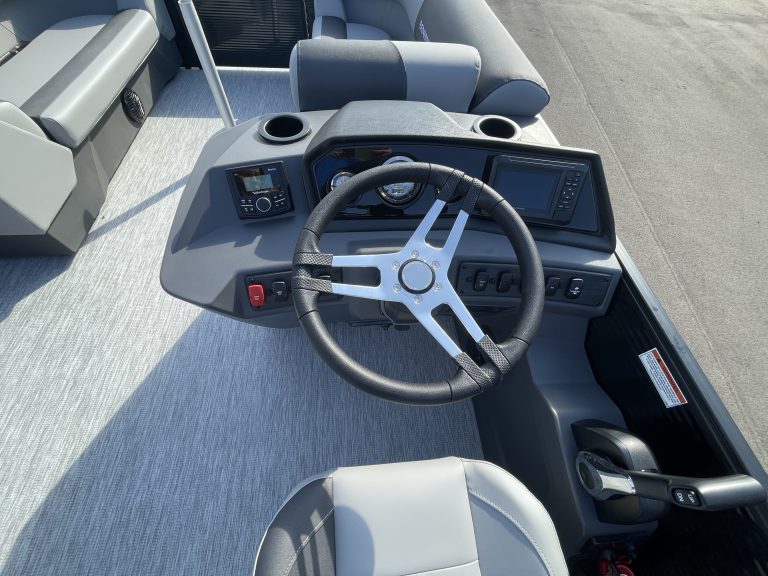 Boat dashboard with steering wheel and controls at Hall's Sport Center.