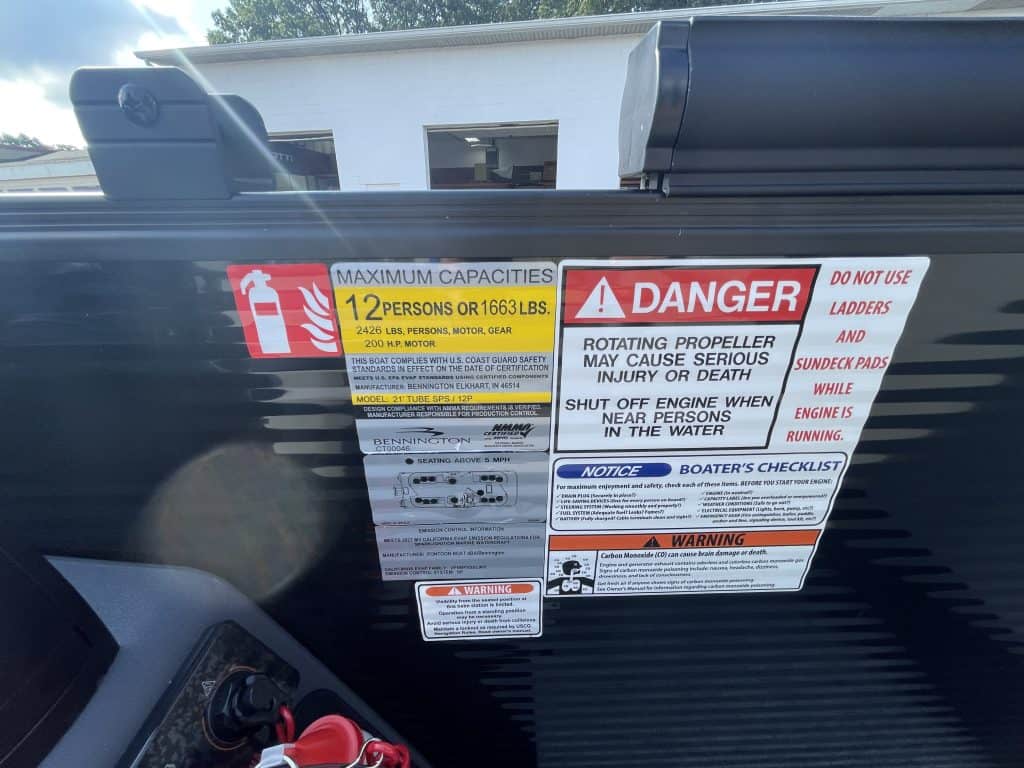 Boat safety labels including maximum capacity and danger warnings.