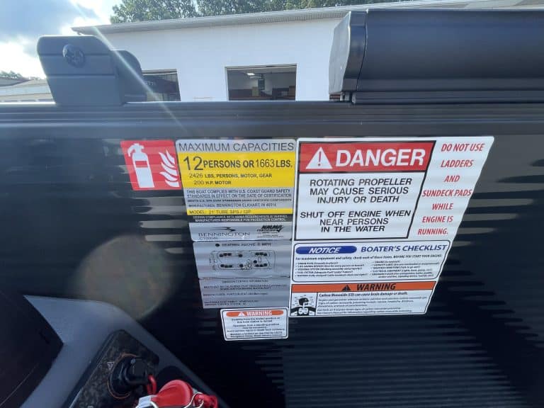 Boat safety labels including maximum capacity and danger warnings.