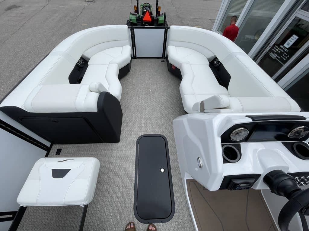 White luxury pontoon boat with seating and steering wheel for sale.