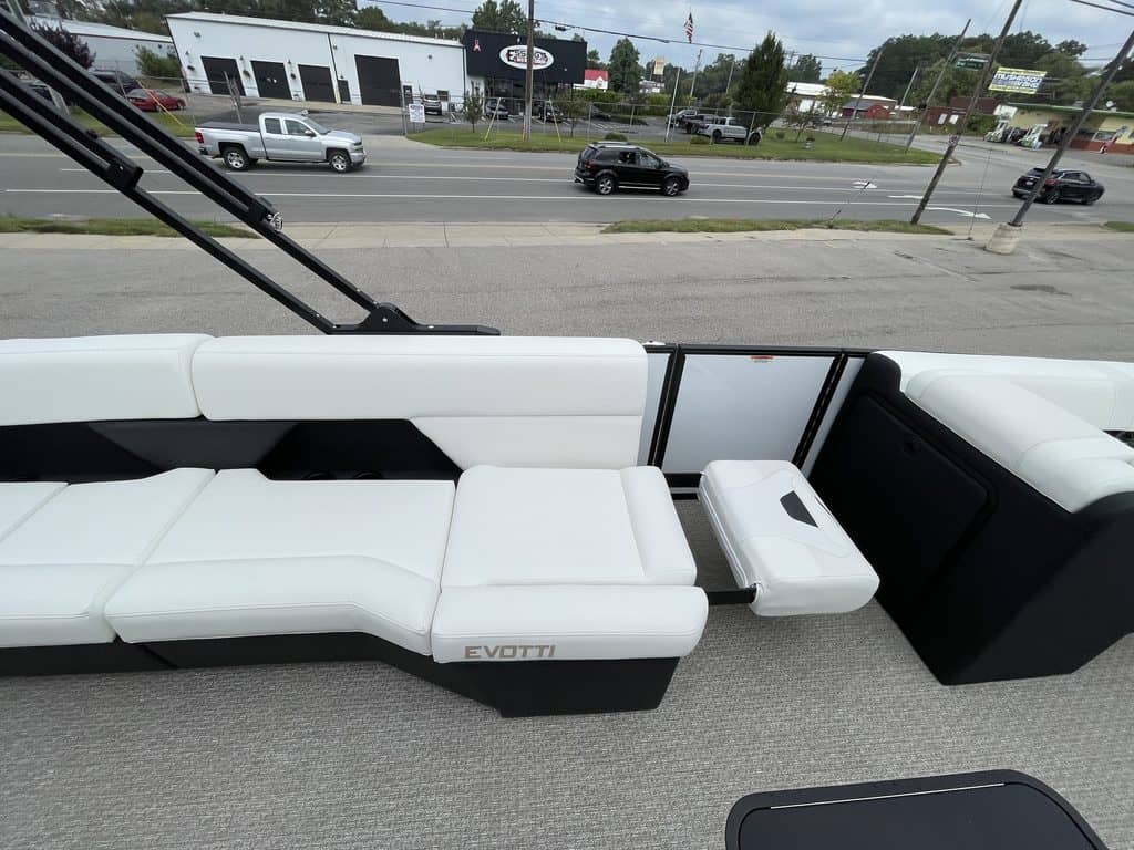 Luxury pontoon boat interior with white seating and a view of the road.