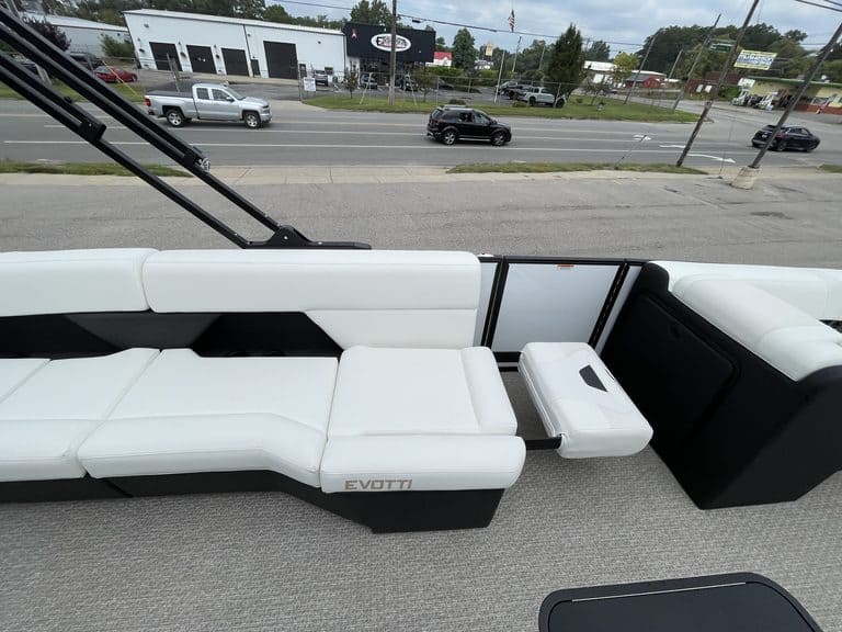 Luxury pontoon boat interior with white seating and a view of the road.