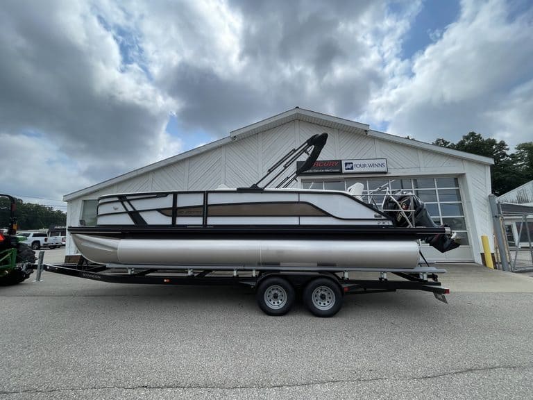 Luxury pontoon boat on trailer outside Hall's Sport Center in Georgia.
