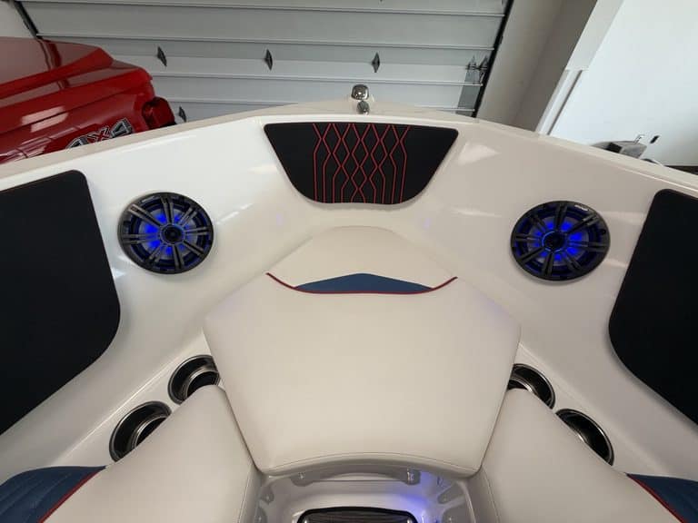 Close-up of the interior of a Glastron GX215 boat with speakers and seating.