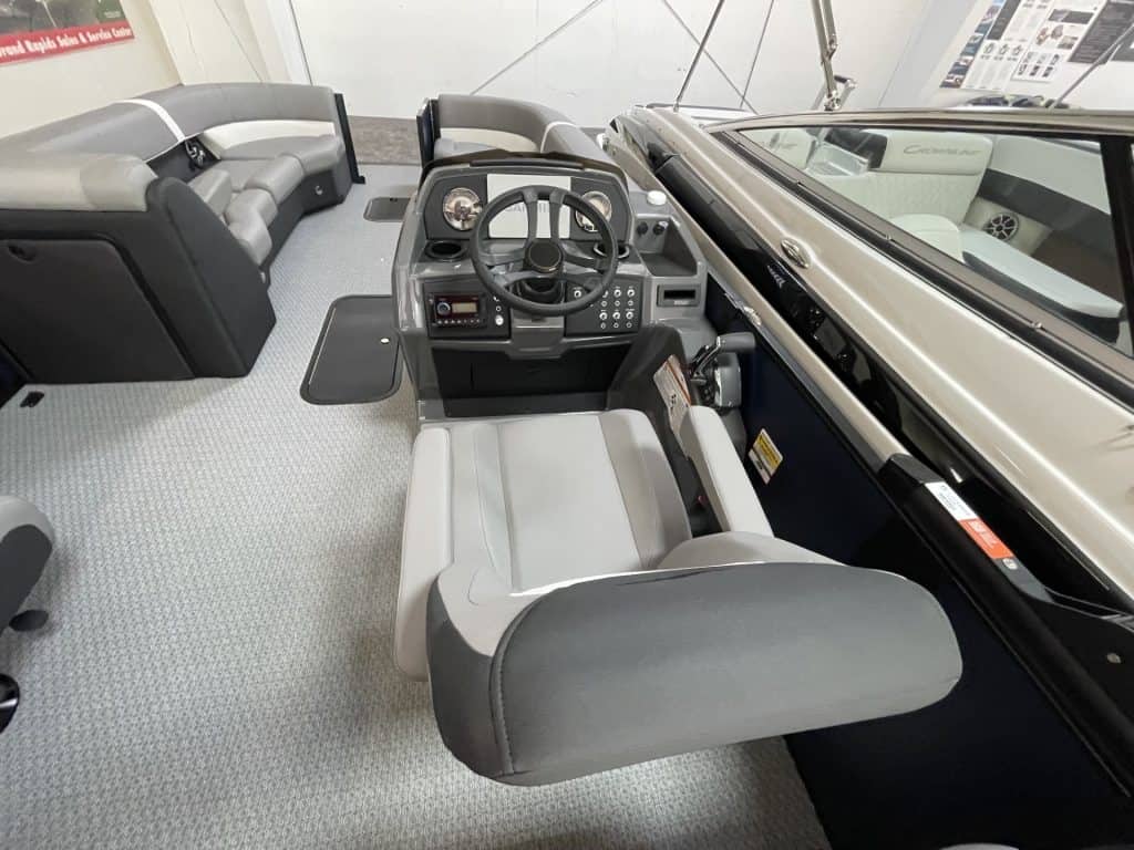 Pontoon boat helm with steering wheel and seating at Hall's Sport Center.