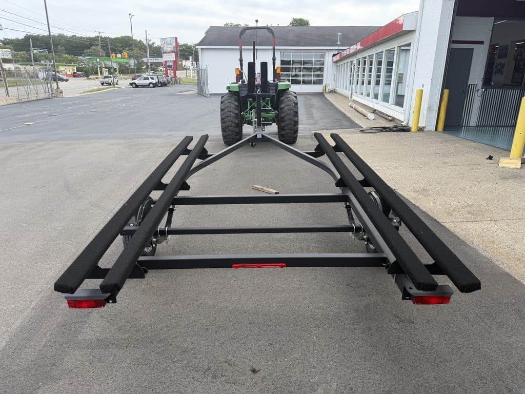Industrial equipment transport trailer with tractor in parking lot.