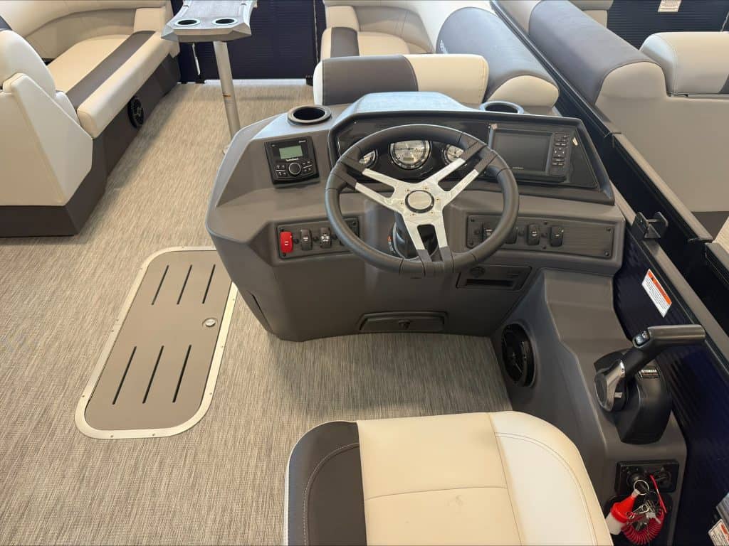 Boat helm with steering wheel and control panel at Hall's Sport Center.