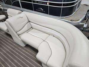 Elegant white pontoon boat seating with plush cushions and curved design.