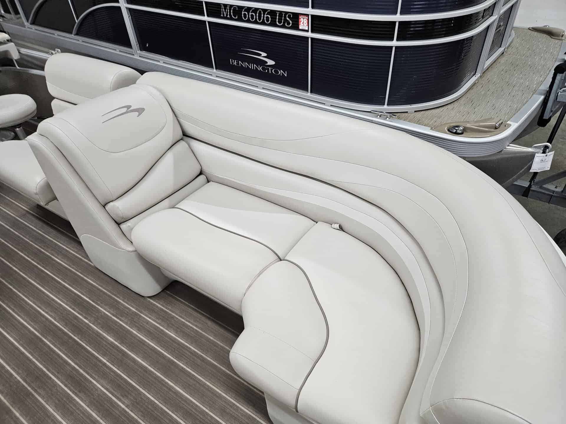 Elegant white pontoon boat seating with plush cushions and curved design.