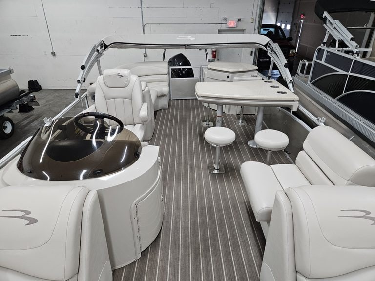 Interior view of a Bennington 2250 GPD pontoon boat with seating and steering console.