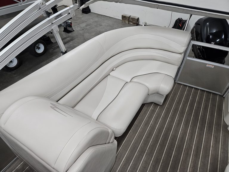 White boat seating area with curved lounge and storage compartments.