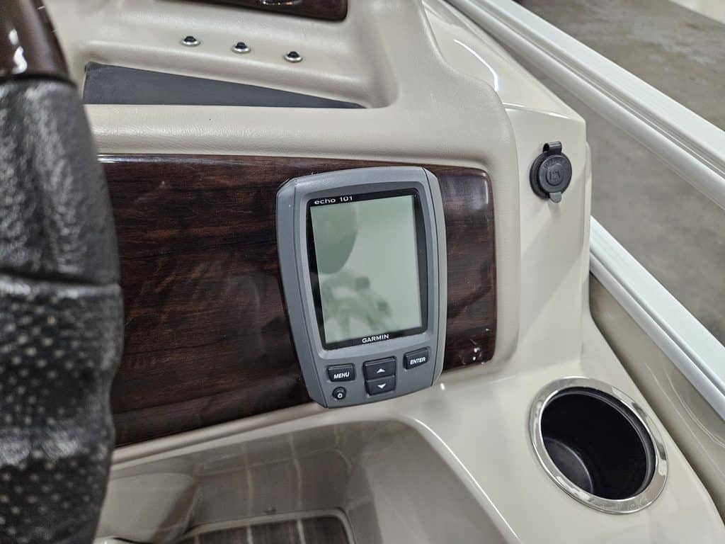 Boat dashboard with GPS device and wood paneling.
