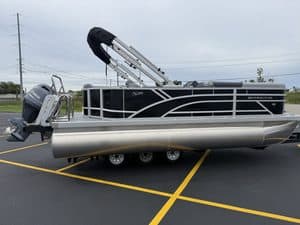 Bennington 20 S1L pontoon boat in parking lot with outboard motor.
