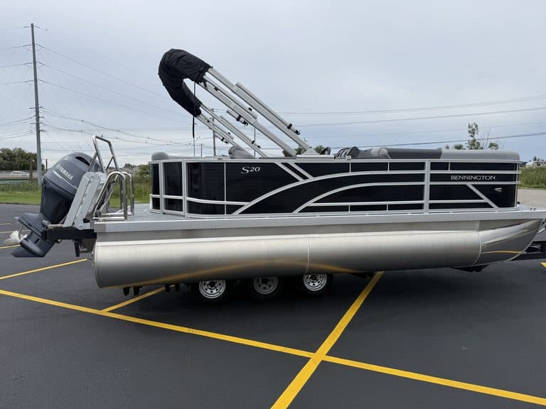 Bennington 20 S1L pontoon boat in parking lot with outboard motor.