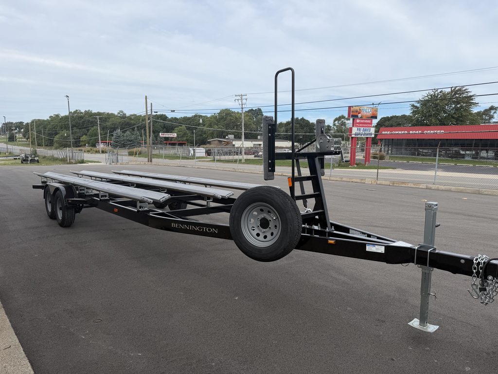 Black flatbed trailer with dual axles and hitch for towing.