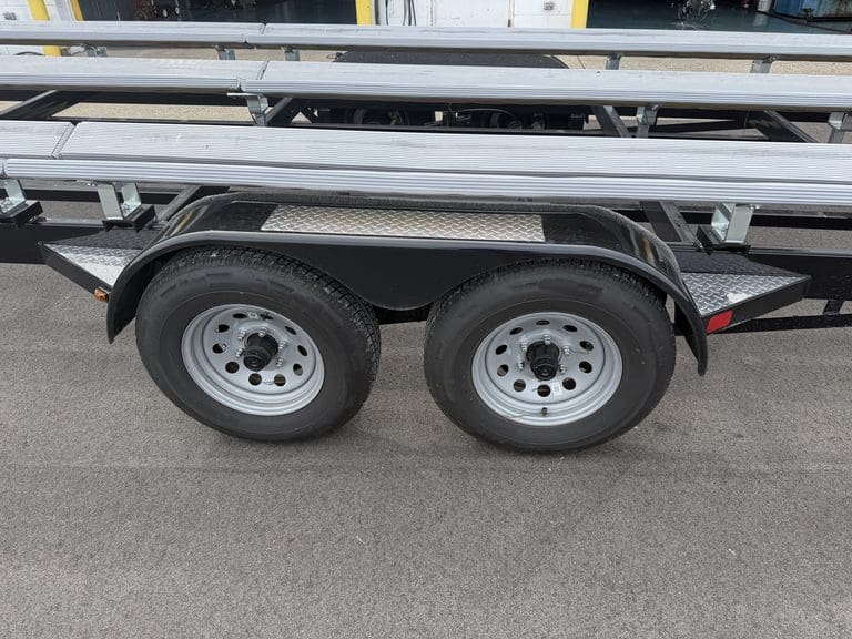 Dual axle trailer with metal frame and tires at Hall's Sport Center.