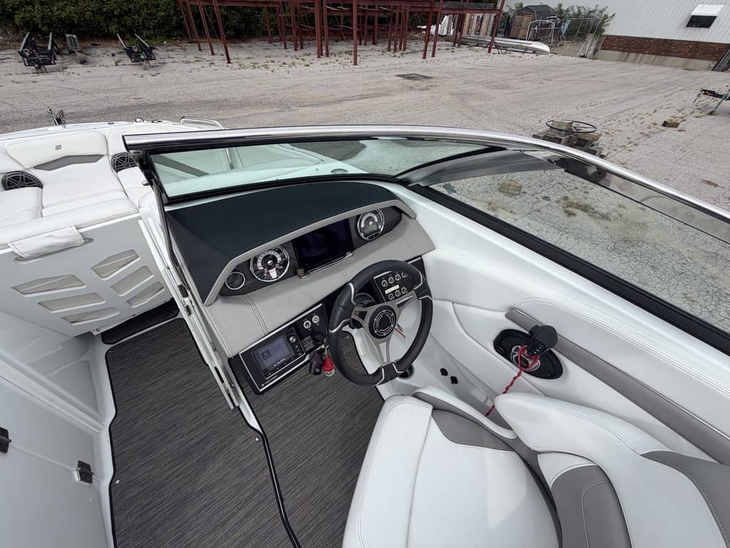 Interior view of a Four Winns H260 boat with dashboard and steering wheel.