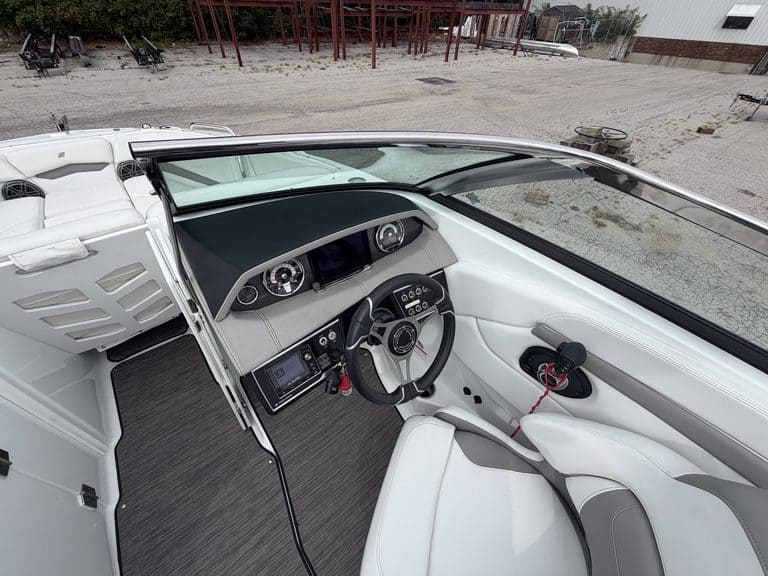 Interior view of a Four Winns H260 boat with dashboard and steering wheel.