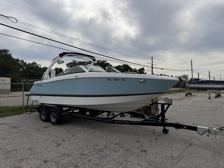 Luxury Four Winns H260 speedboat on trailer at marina.