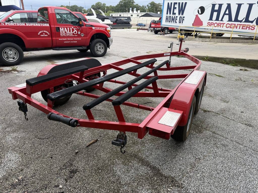Red boat trailer parked outside Hall's Sport Center in the lot.