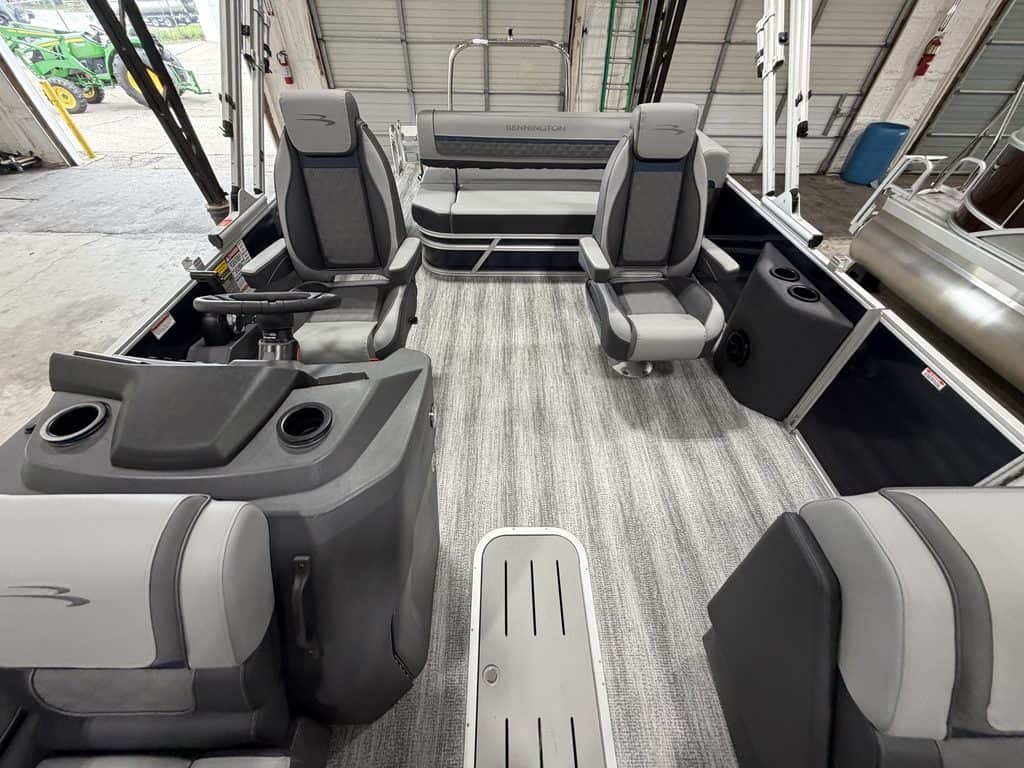 Interior view of a Bennington 23 SSB pontoon boat with seating and steering console.