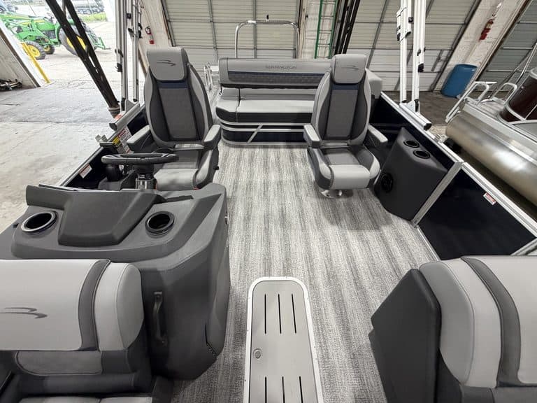 Interior view of a Bennington 23 SSB pontoon boat with seating and steering console.
