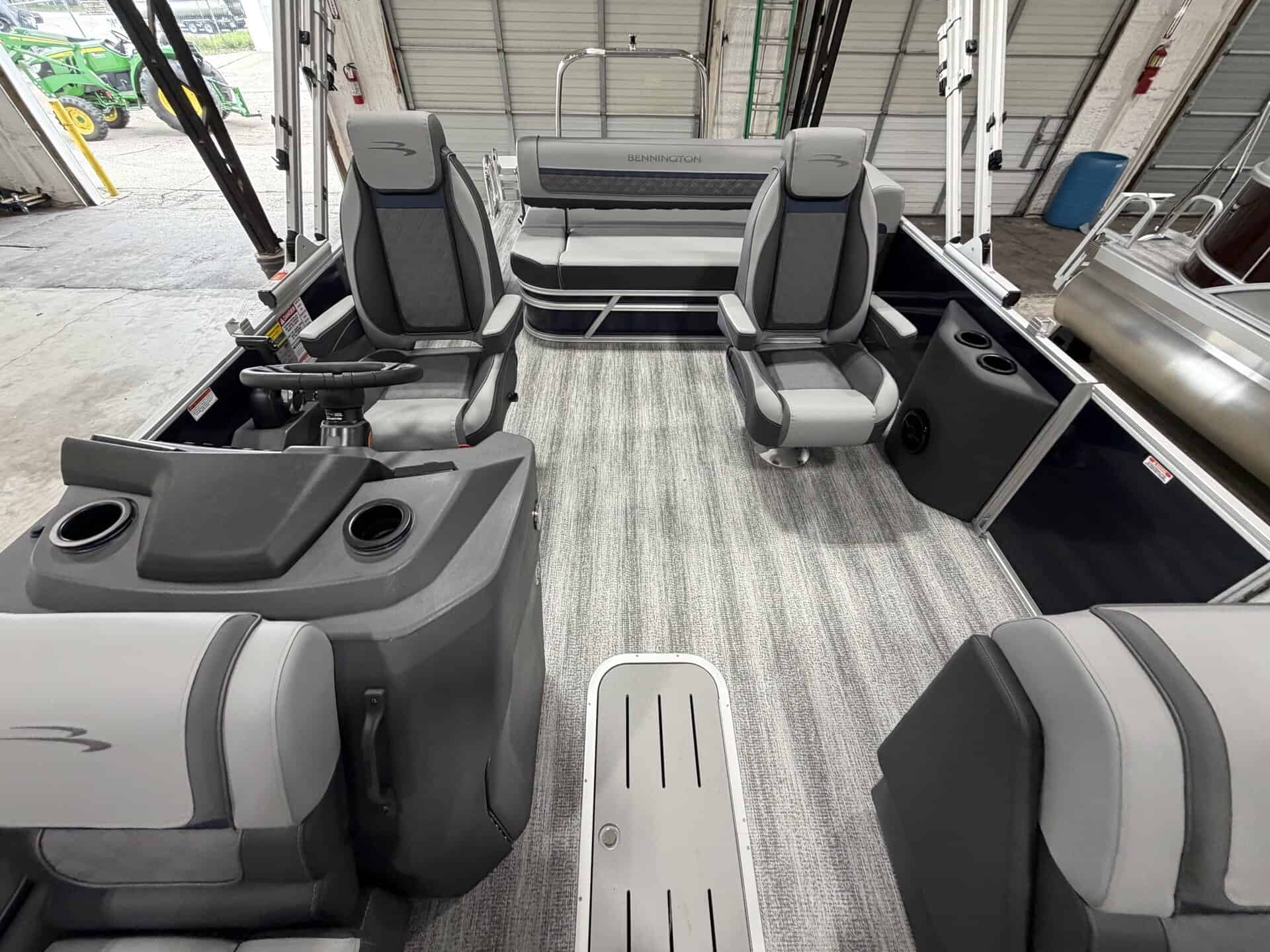 Interior view of a Bennington 23 SSB pontoon boat with seating and steering console.