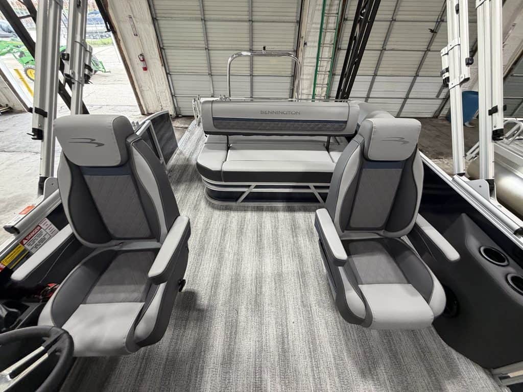 Interior view of a Bennington 23 SSB pontoon boat with seating and steering area.