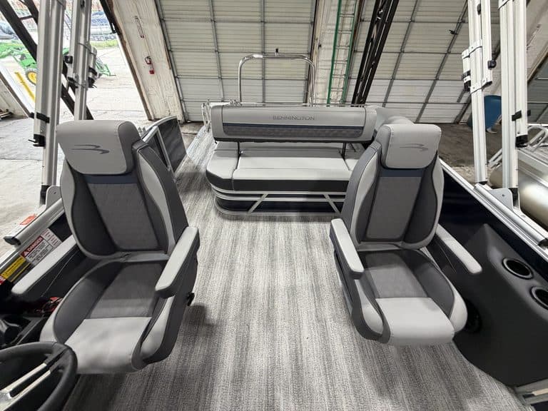 Interior view of a Bennington 23 SSB pontoon boat with seating and steering area.