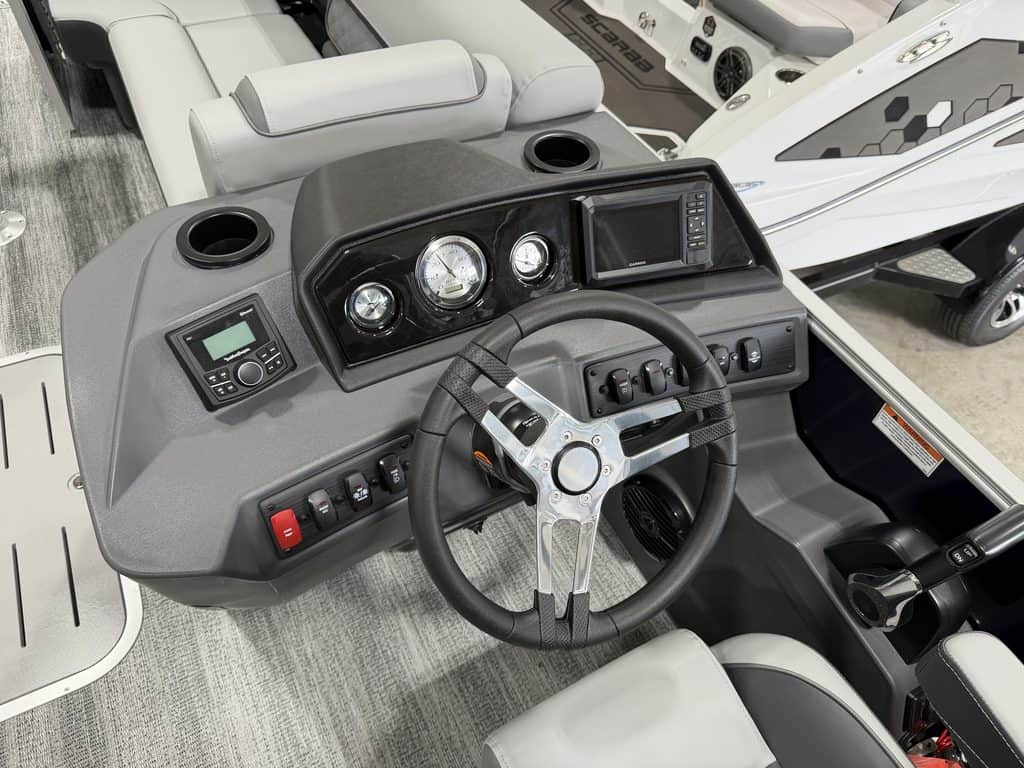 Close-up of boat dashboard with steering wheel and controls at Hall's Sport Center.