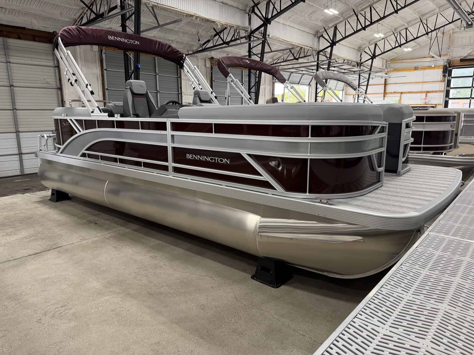 Bennington 22 SSR pontoon boat inside a showroom with a metal roof.