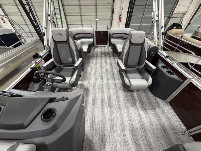 Interior view of a Bennington 22 SSR pontoon boat with seating and steering area.