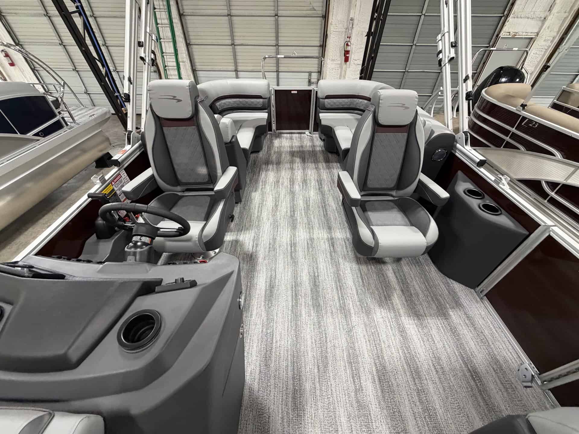 Interior view of a Bennington 22 SSR pontoon boat with seating and steering area.