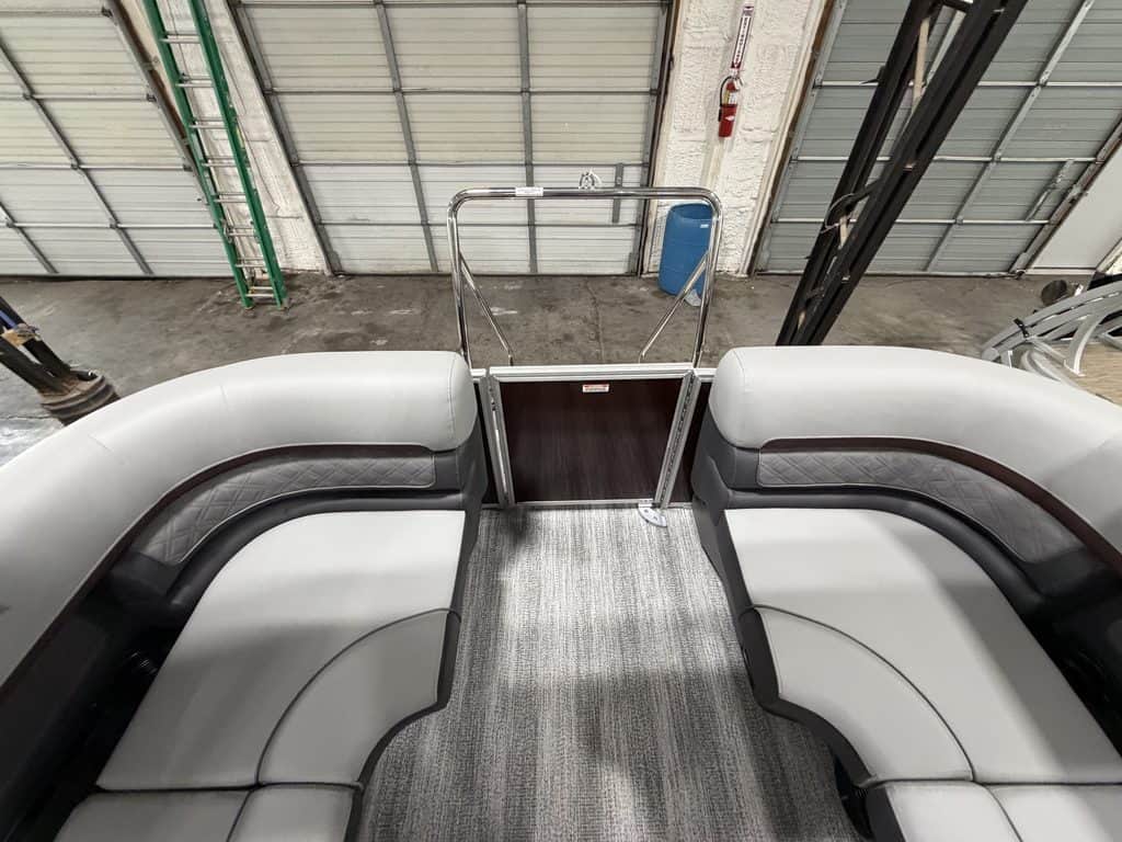 View of boat's spacious seating area with gray and black cushions.