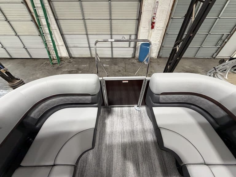 View of boat's spacious seating area with gray and black cushions.