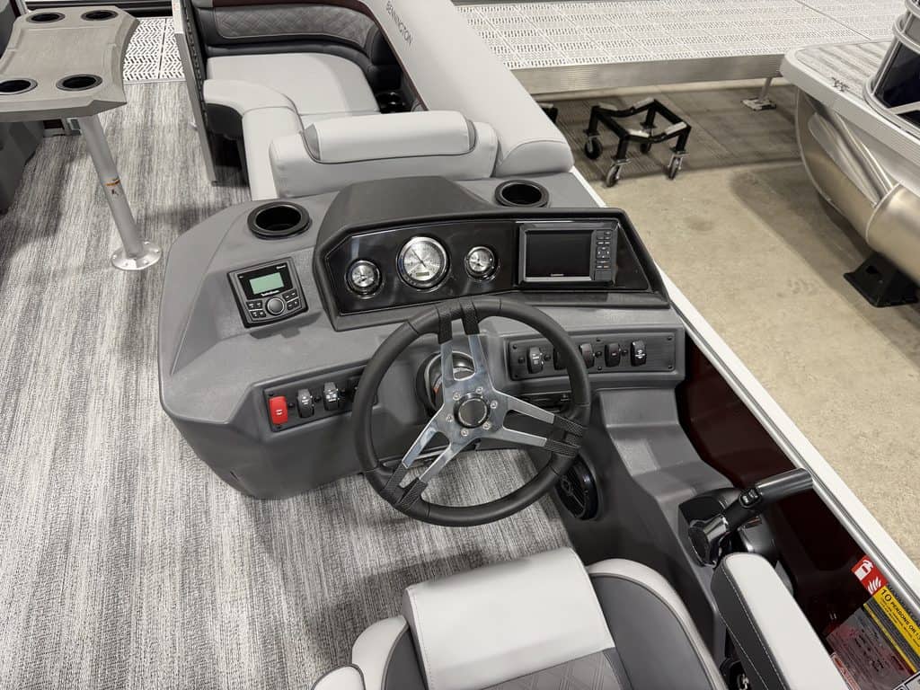 Boat dashboard with steering wheel, gauges, and controls at Hall's Sport Center.
