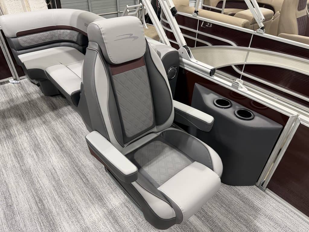 Luxury pontoon boat seat with gray and beige upholstery and armrests.