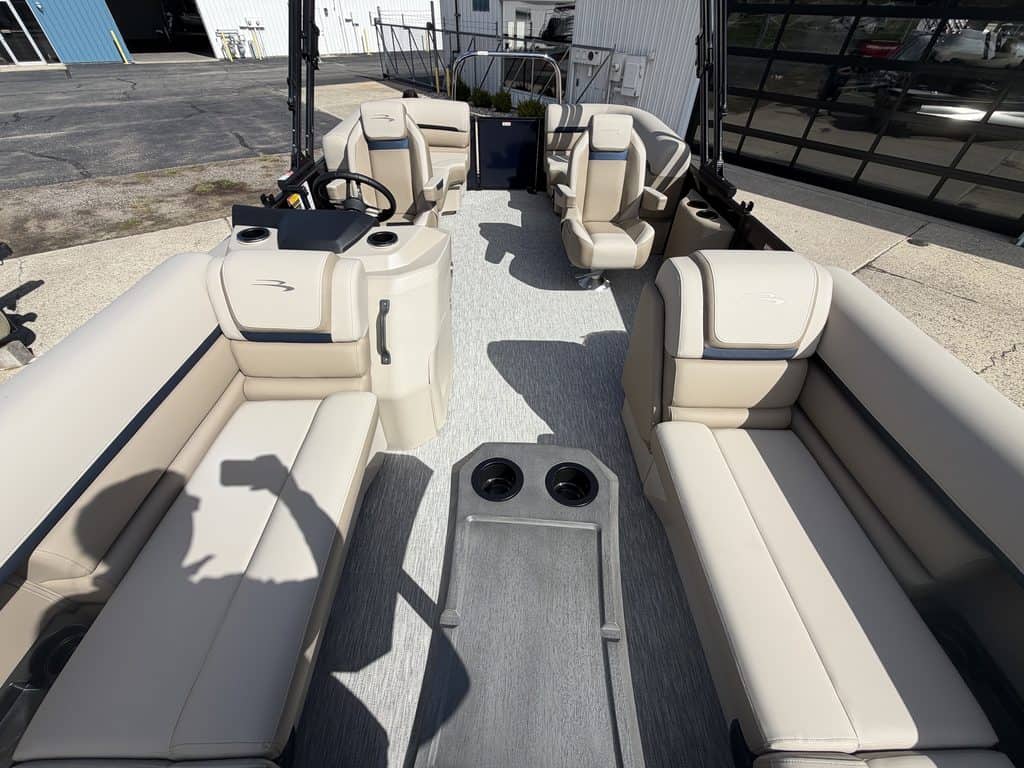 Interior view of a Bennington 21 SSR pontoon boat with beige seating and steering console.