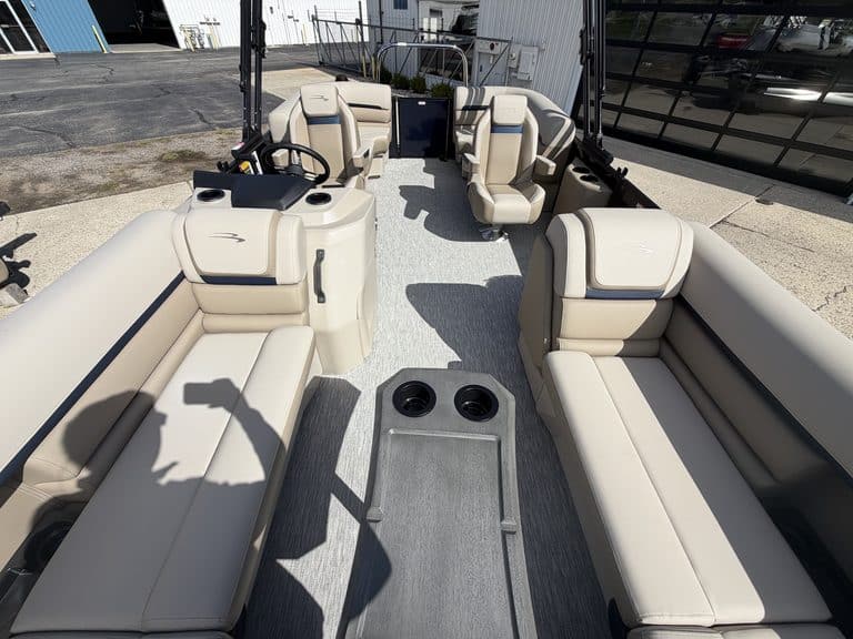 Interior view of a Bennington 21 SSR pontoon boat with beige seating and steering console.