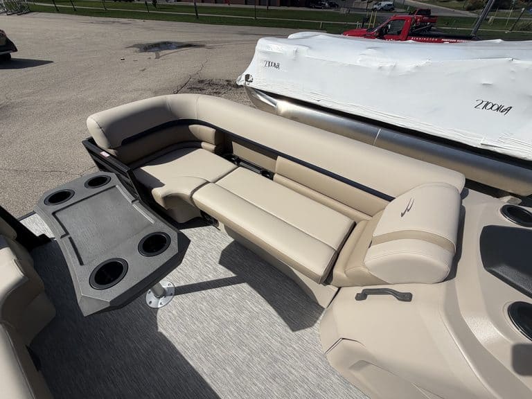 Luxury Bennington 21 SSR pontoon boat with beige seating and cup holders.